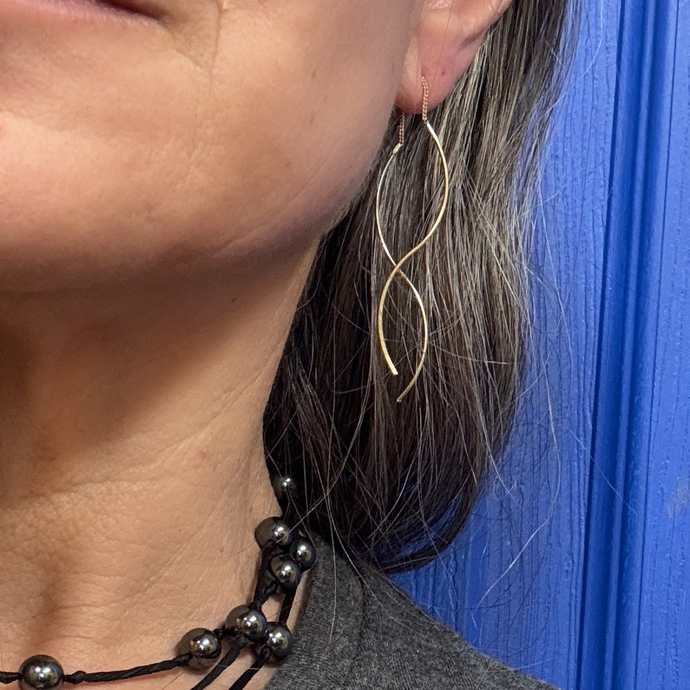 close up of woman's ear with double helix threader earrings in sterling