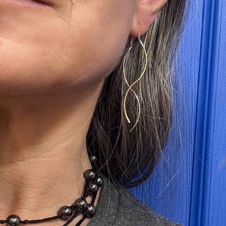 close up of woman's ear with double helix threader earrings in sterling