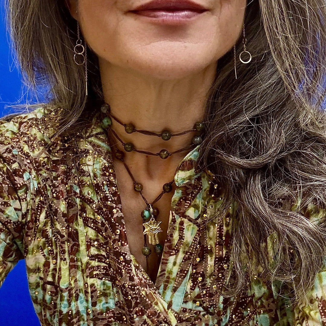 woman wearing green azurite backbeads as a wrapped necklace with hamsa