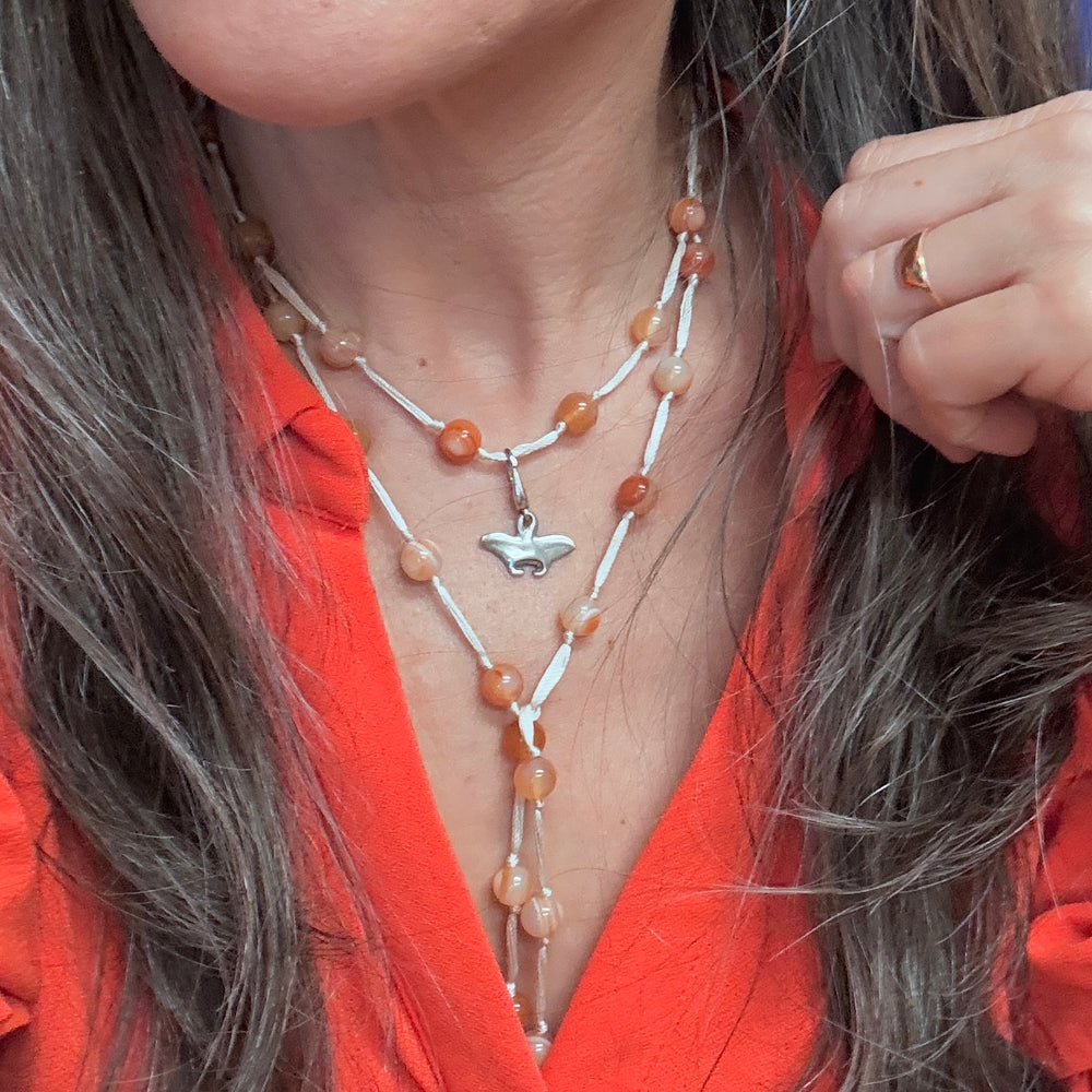 orange agate with manta ray charm on model in orange shirt