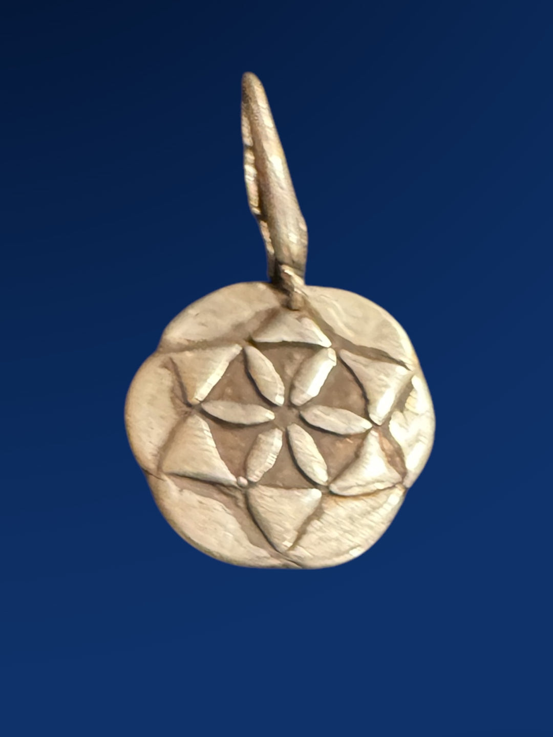 silver seed of life charm on blue background