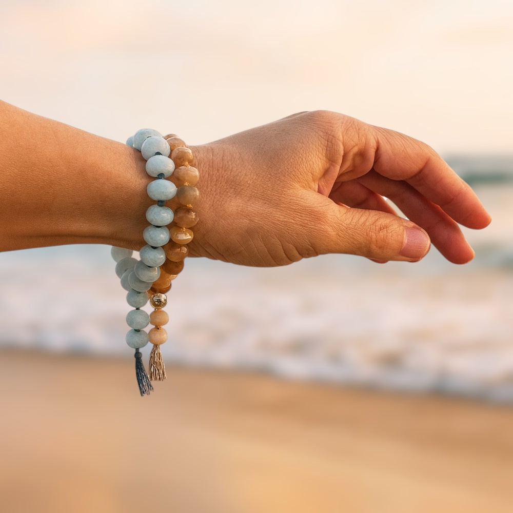 Sunkissed sunstone and salty amazonite gemstone bracelets on wrist by beach