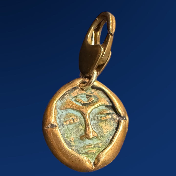 bronze emerge charm on blue background