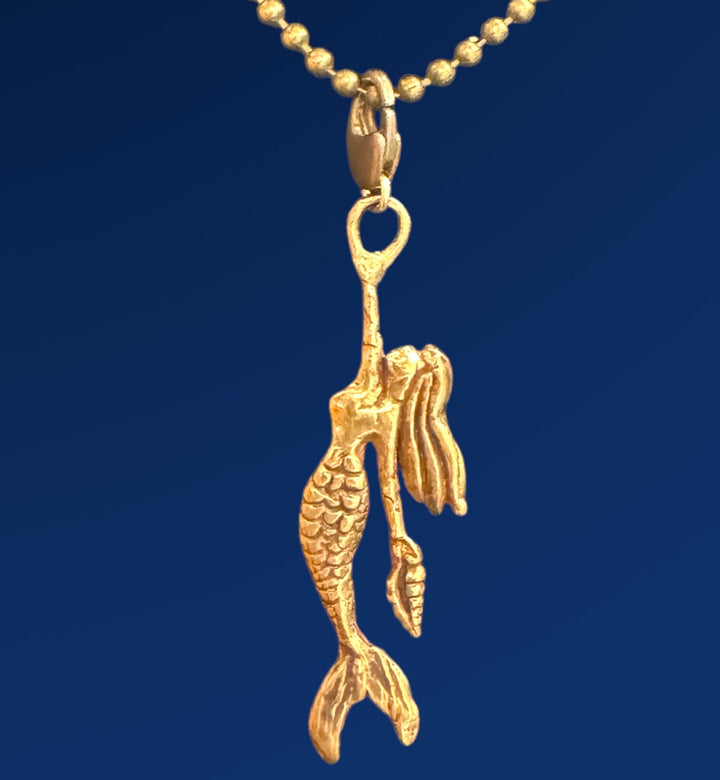 Gold mermaid pendant on a blue background