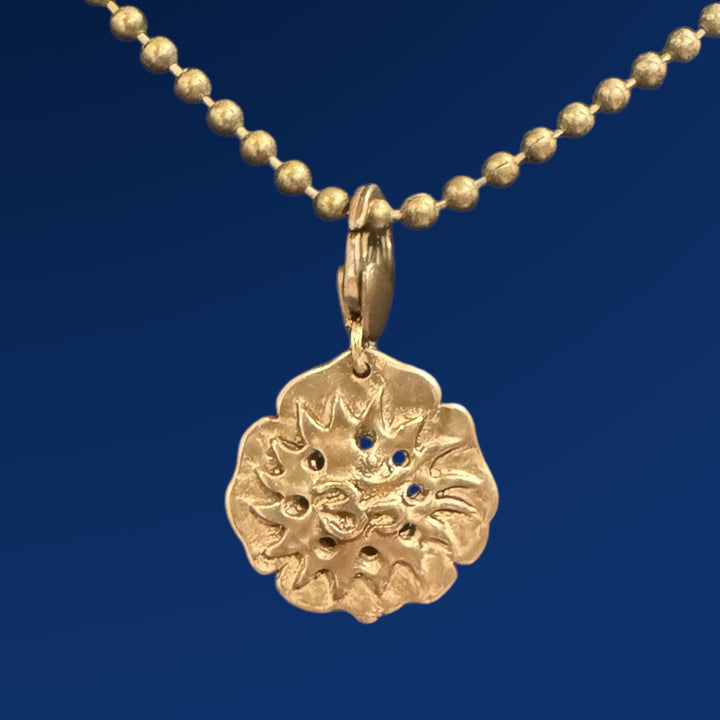 bronze om lotus flower pendant on chain on blue background