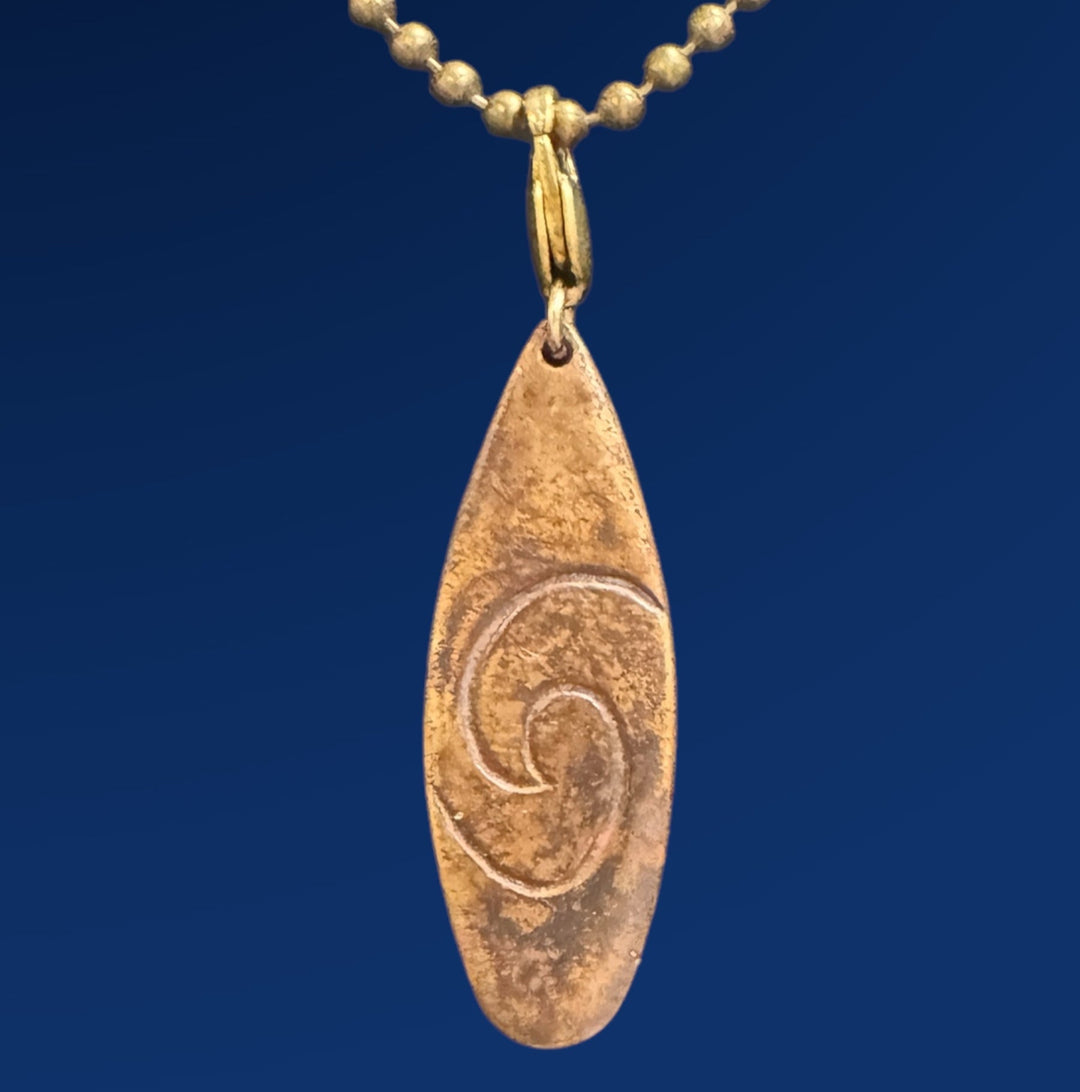 bronze surfboard pendant on chain on blue background