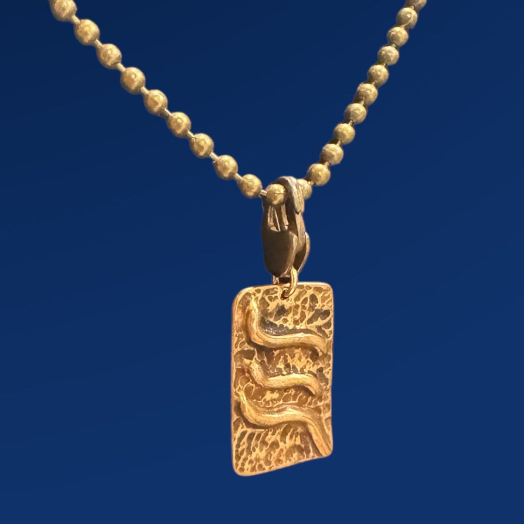 bronze tao air charm on chain and blue background