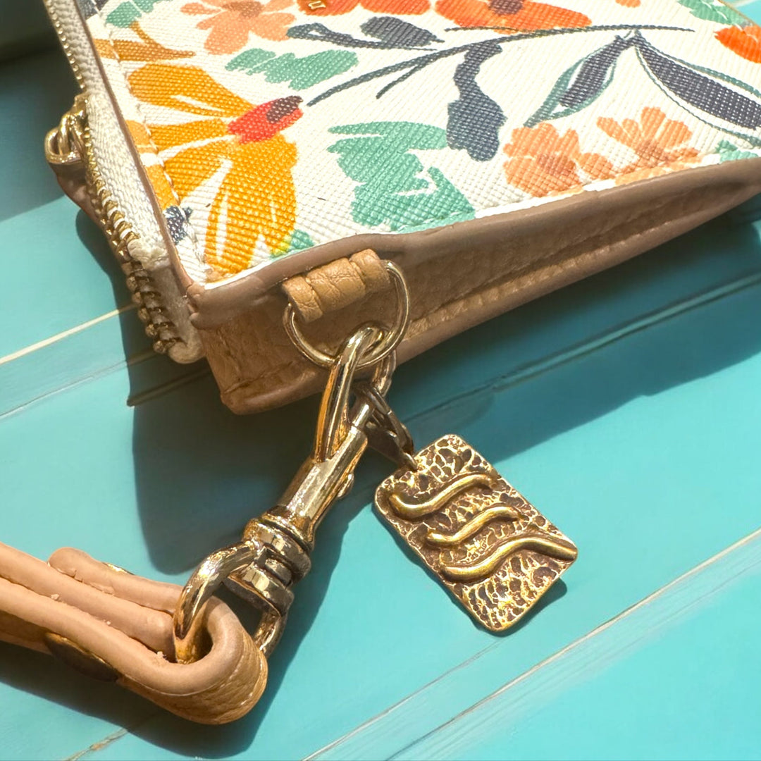 bronze air charm on floral purse and turquoise table