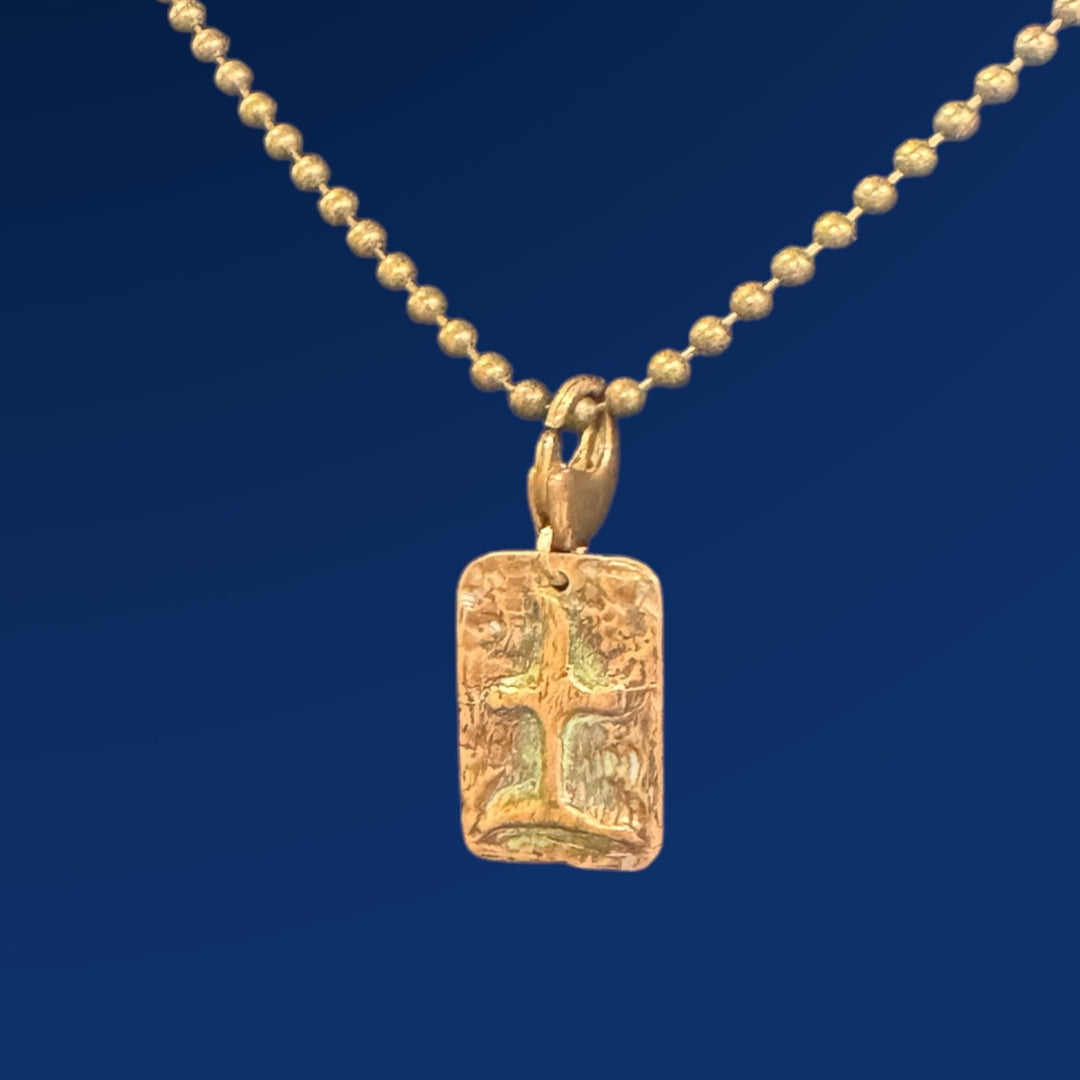 bronze tao earth charm on chain and blue background