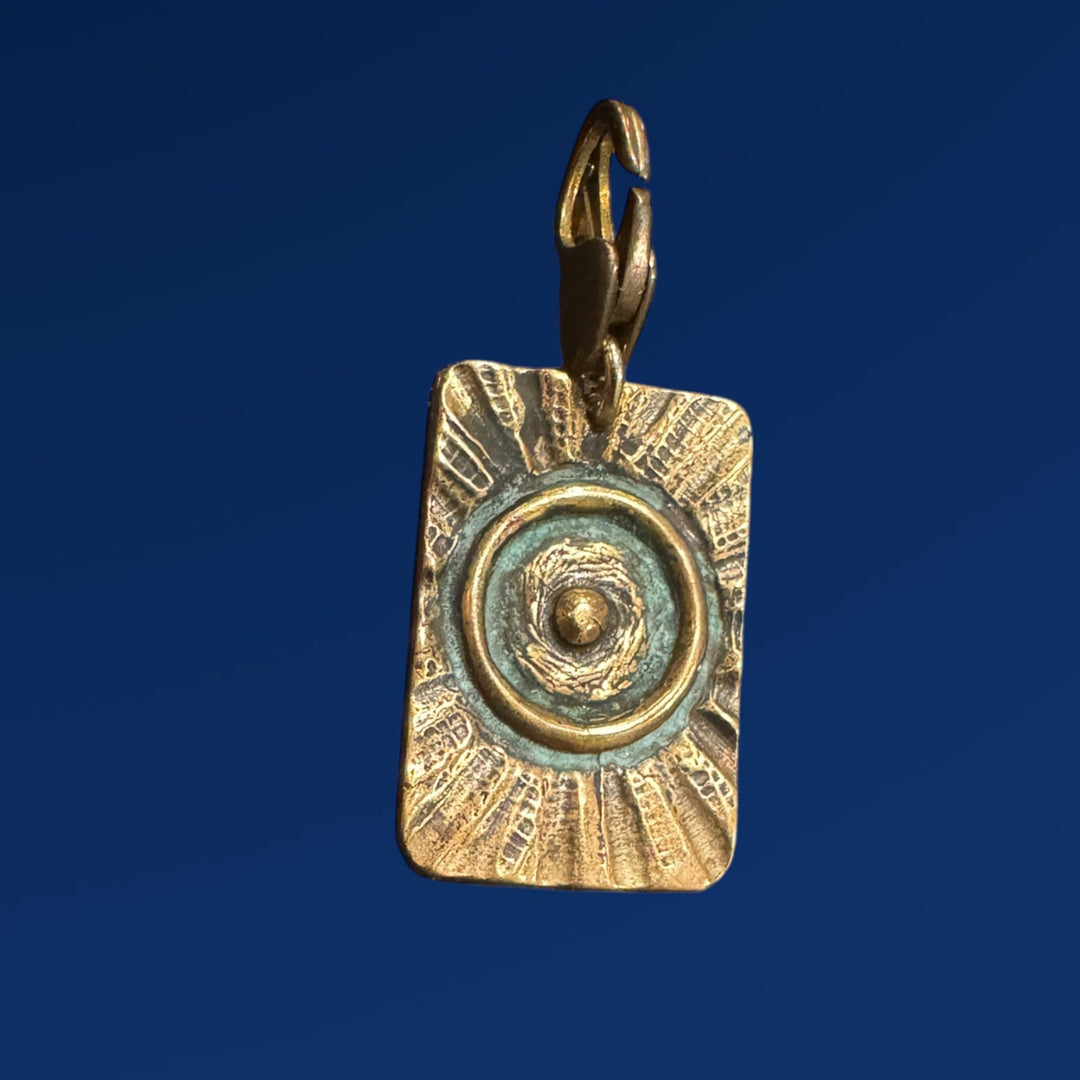bronze tao fire pendant on blue background