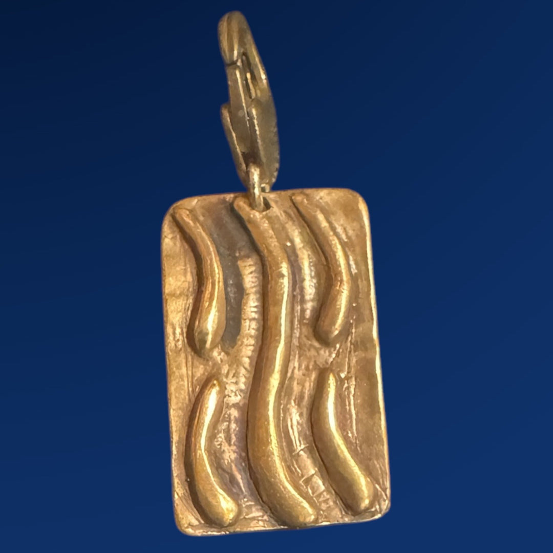 bronze tao water charm on blue background