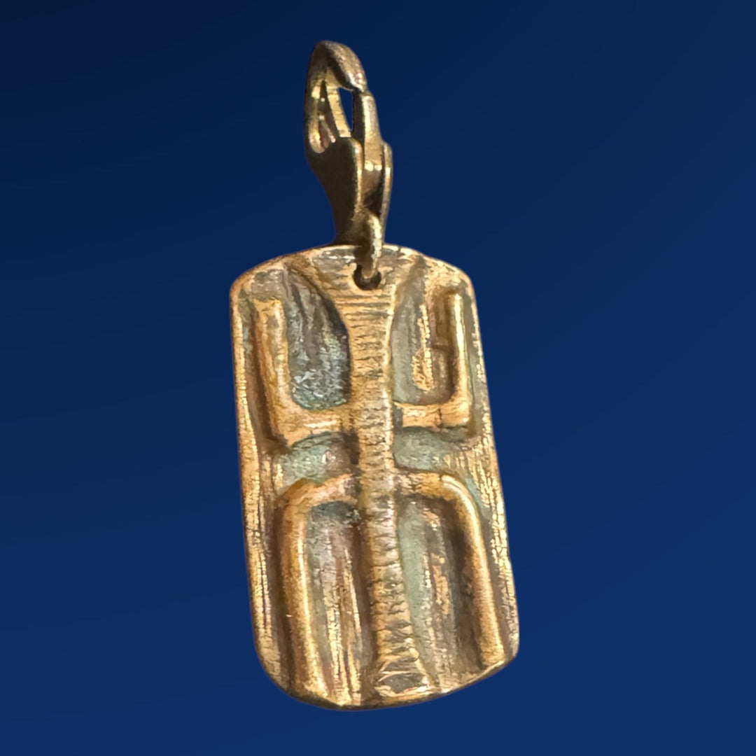 bronze tao wood charm on blue background