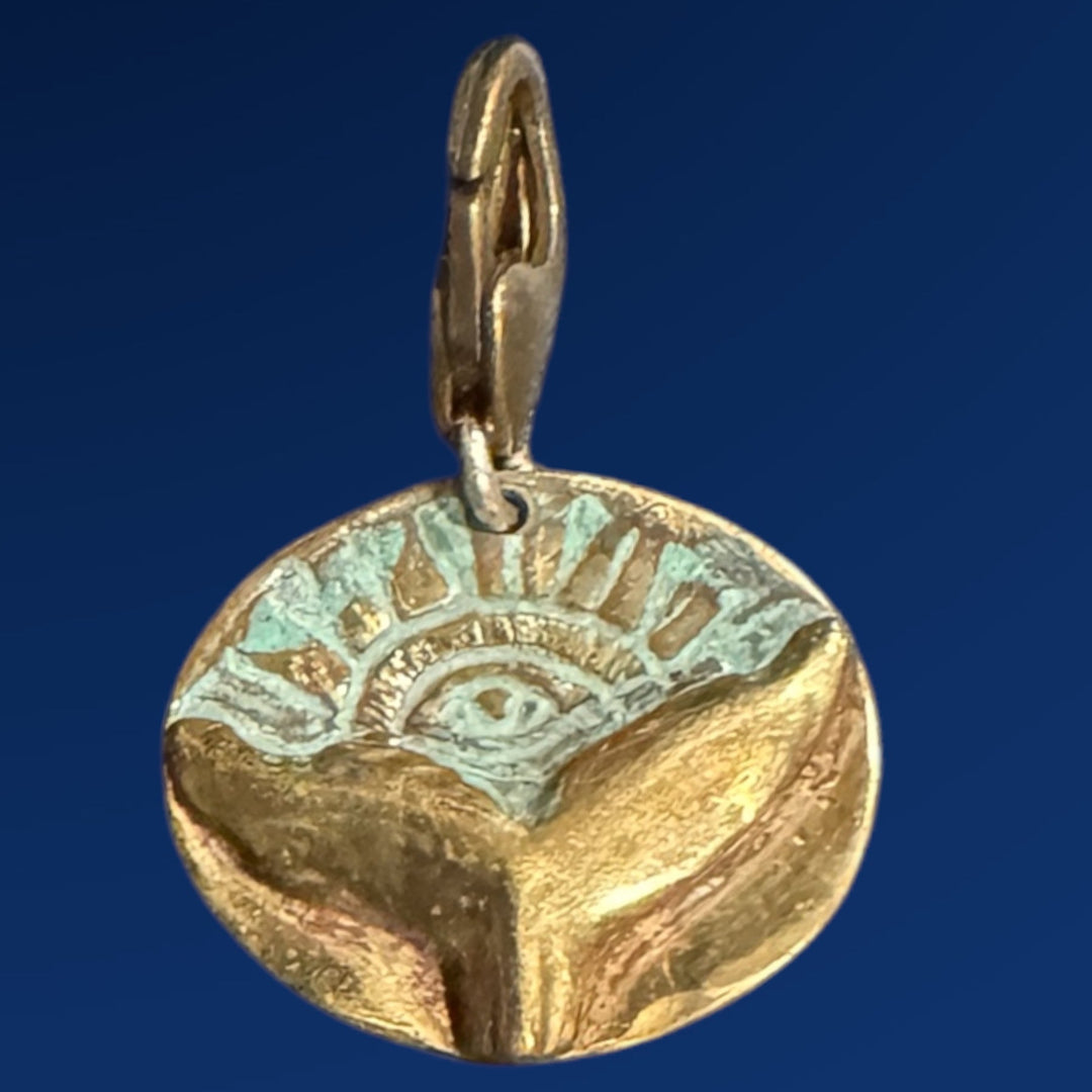 bronze whale tail charm on blue background