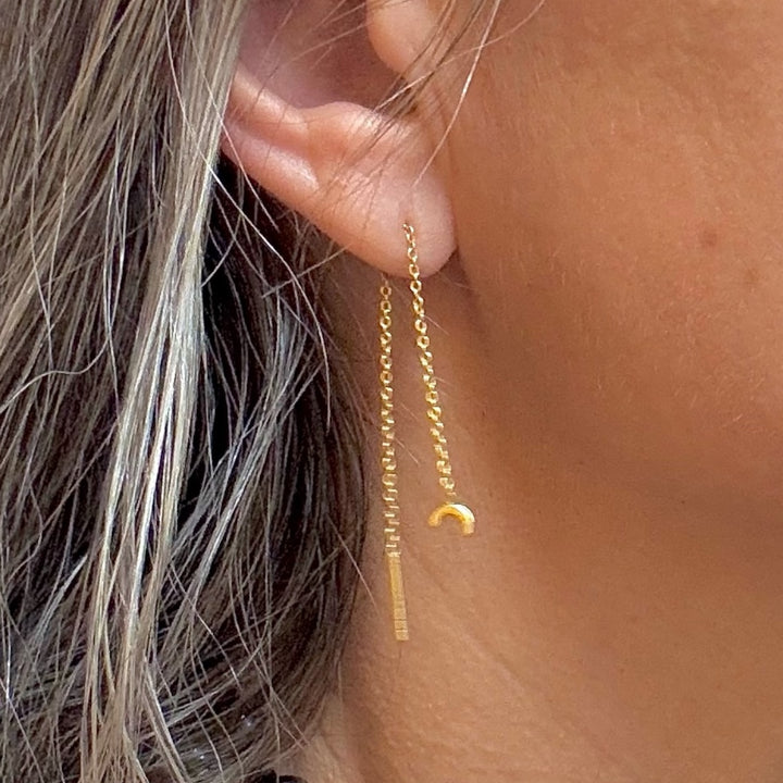 close up of moon threader gold earrings in ear