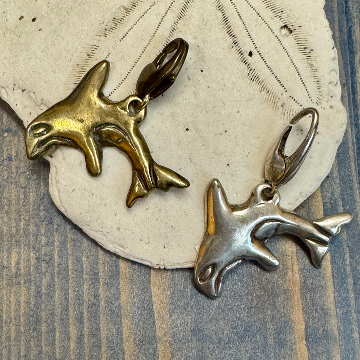 silver and bronze orca charm on sand dollar