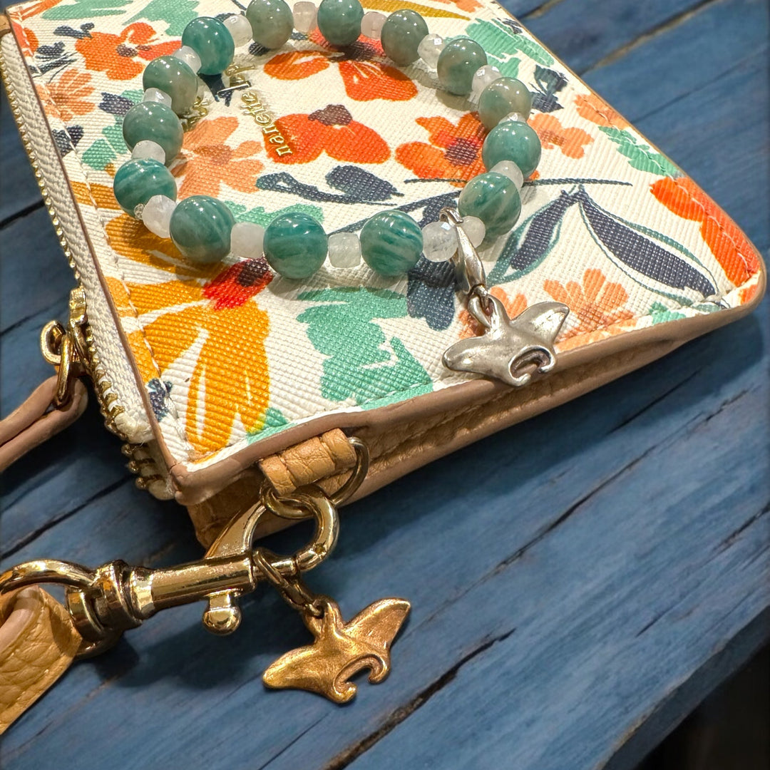 manta ray charms on purse and bracelet on blue table