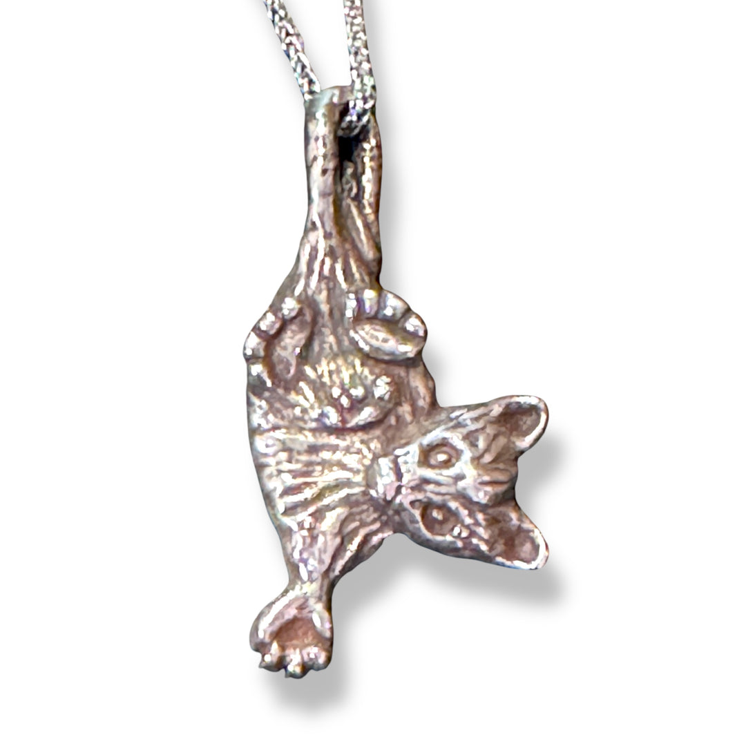 up close silver opossum charm on chain on white background
