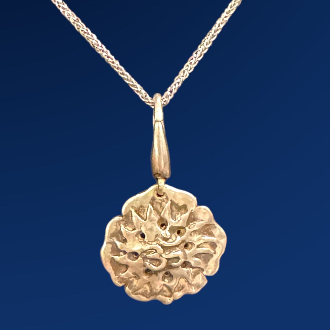 silver meditation charm on chain blue background