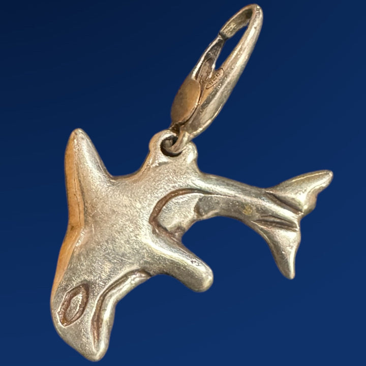 silver orca charm on blue background