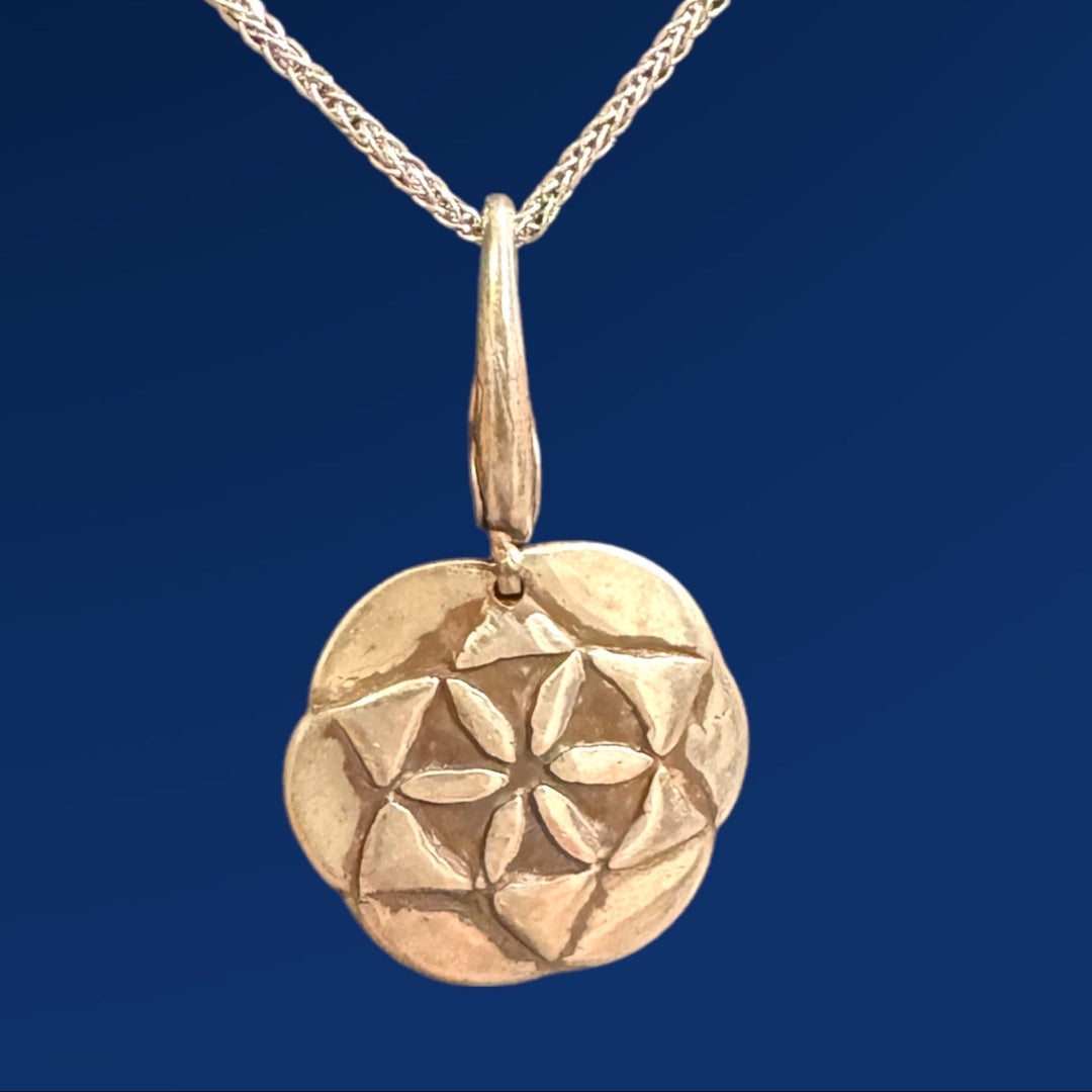 silver seed of life pendant on chain on blue background