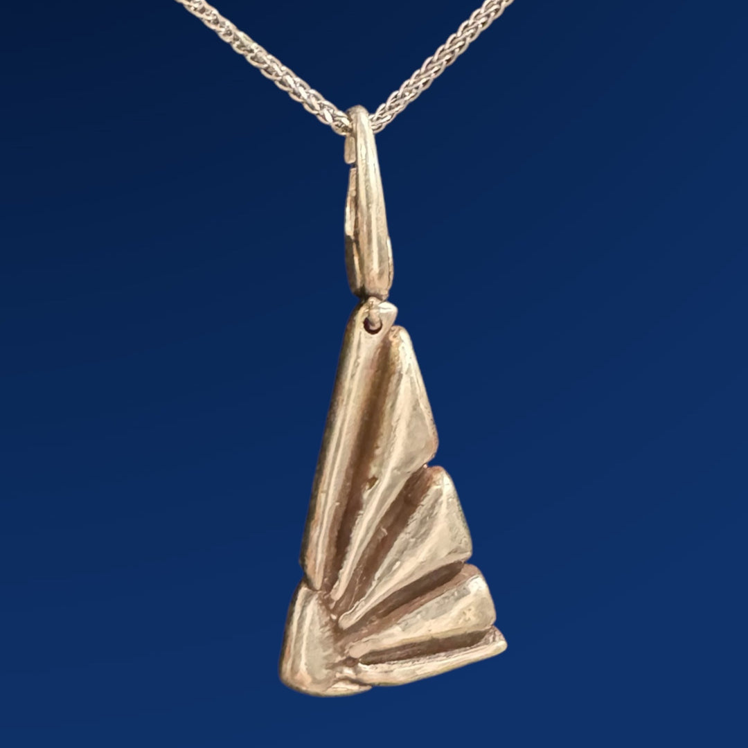 silver flower charm on chain on blue background