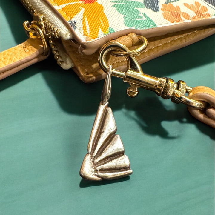 close up of floral purse with flower charm on turquoise background