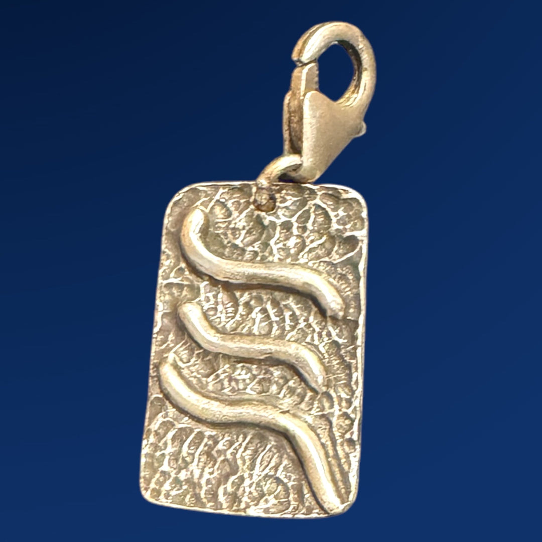 silver tao air charm on blue background