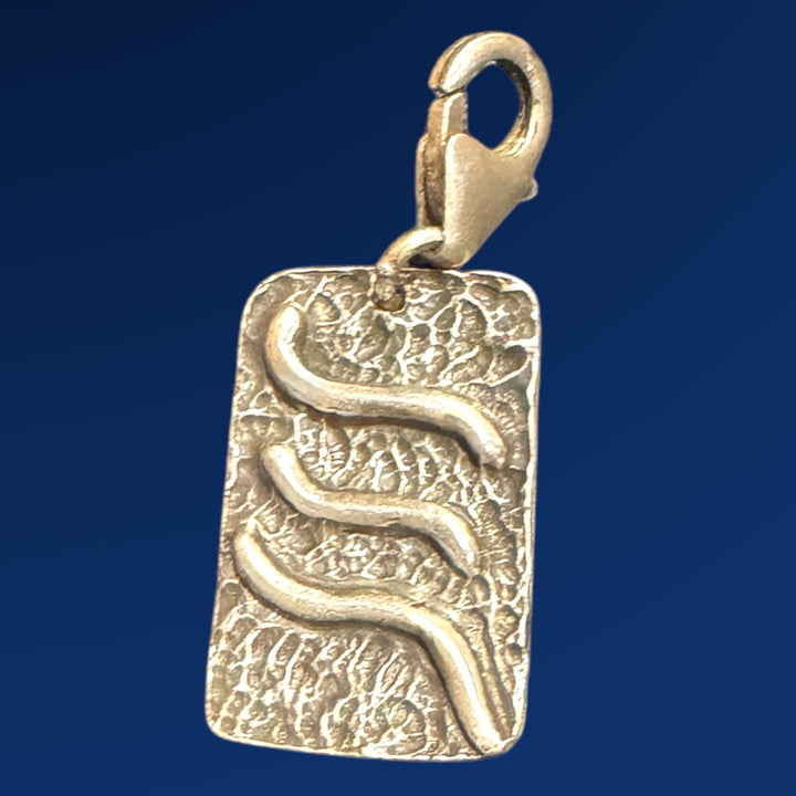 silver tao air charm on blue background