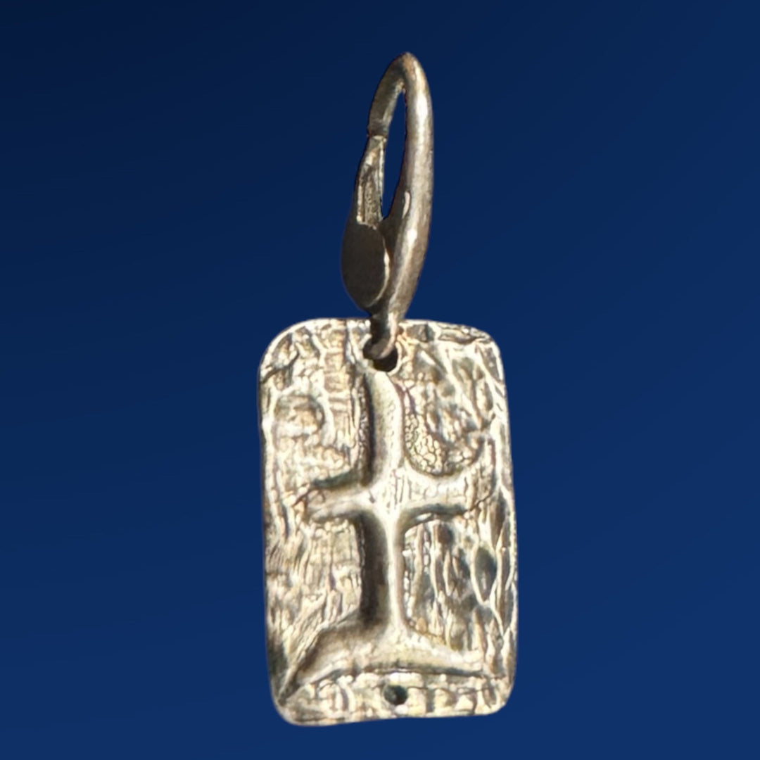 silver tao earth charm on blue background