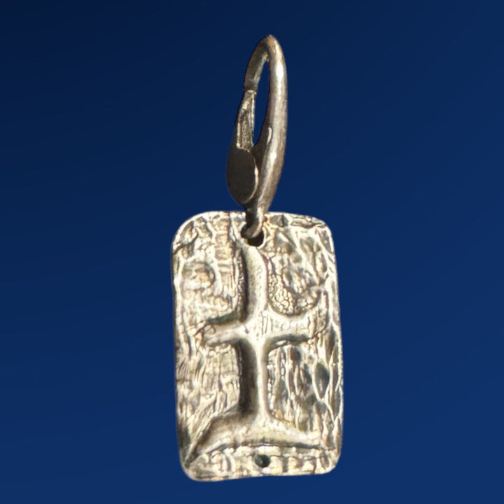 silver tao earth charm on blue background