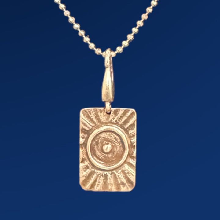 tao fire charm on chain and blue background