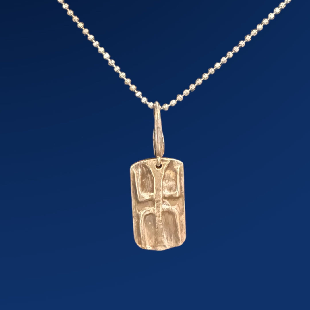 silver tao wood charm on chain and blue background