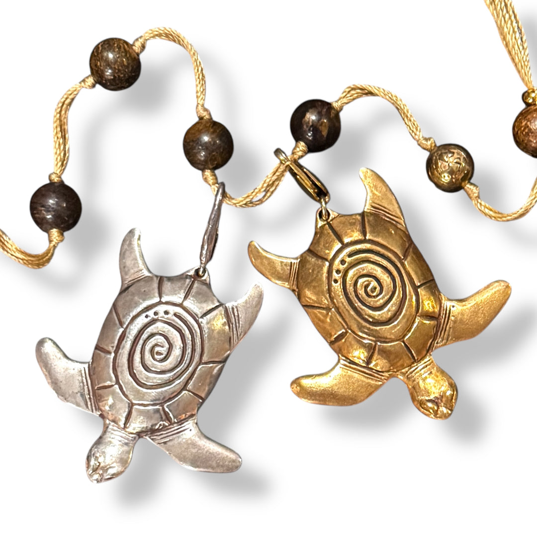 two sea turtle charms with spiral shells on bronzite backbeads