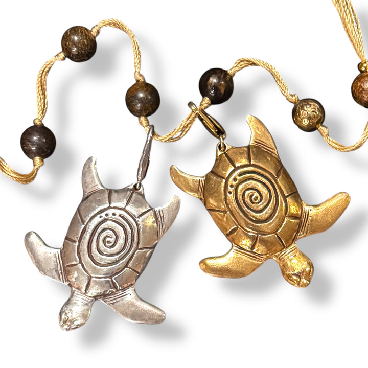 two sea turtle charms with spiral shells on bronzite backbeads