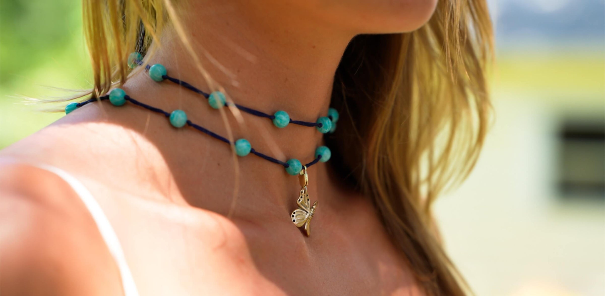 model wearing backbeads and butterfly necklace charm pendant