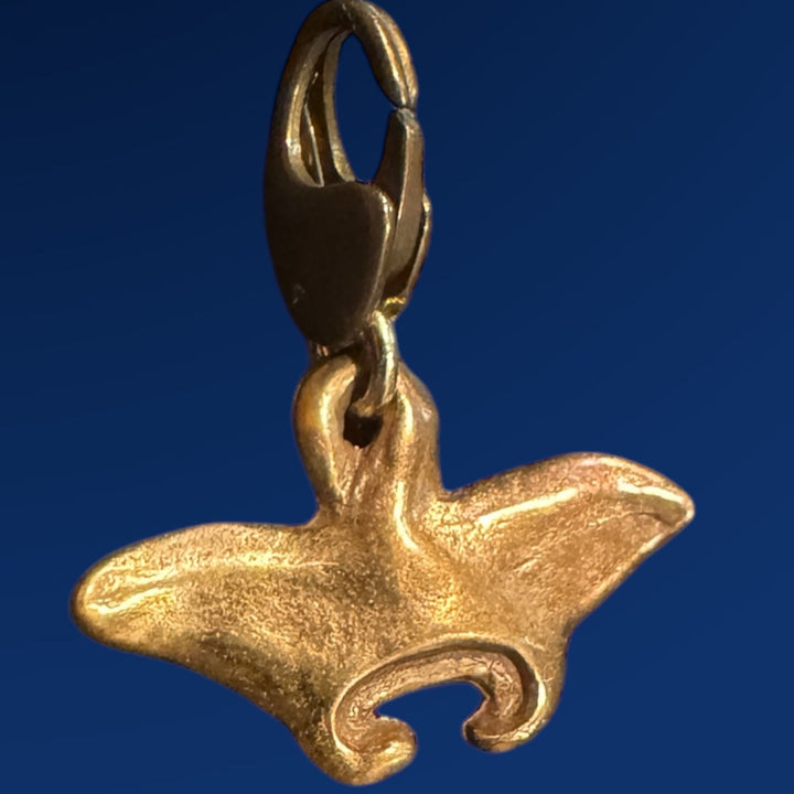 bronze manta ray charm on blue background 