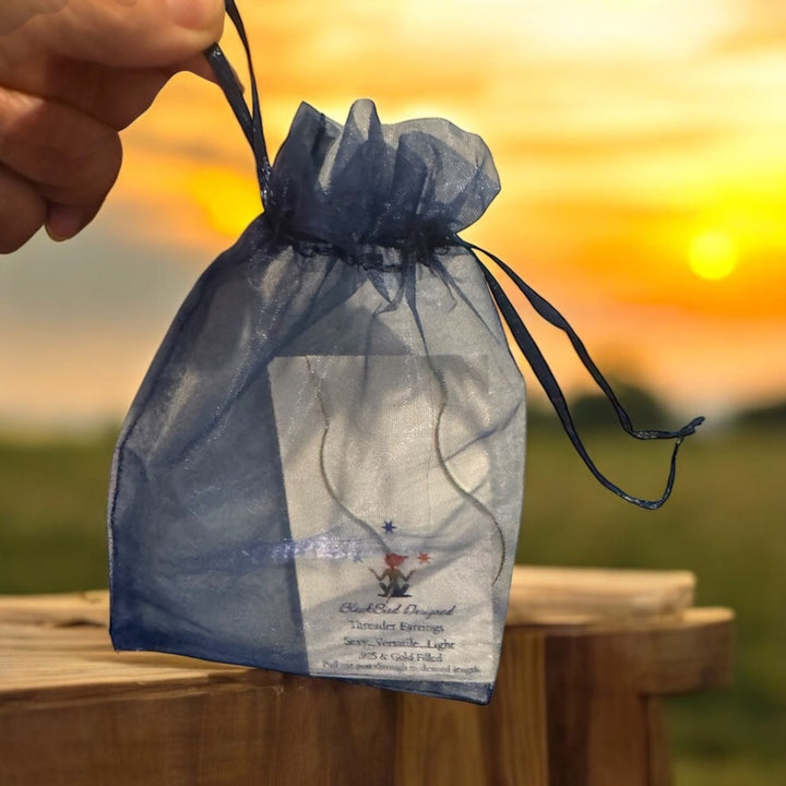 threader earrings in blue string gift bag 

